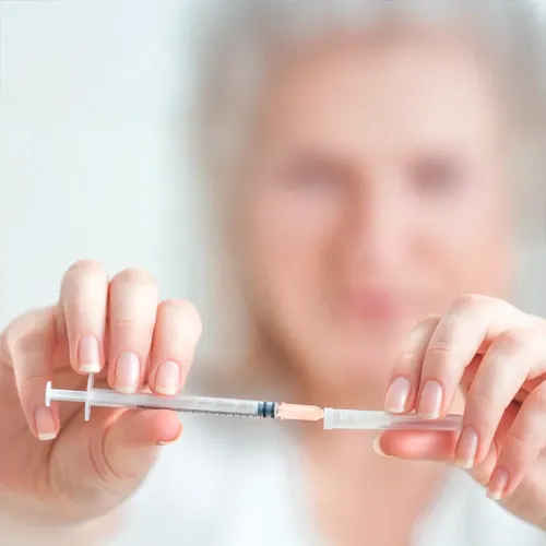 Person preparing spinal injection needle during medical procedure